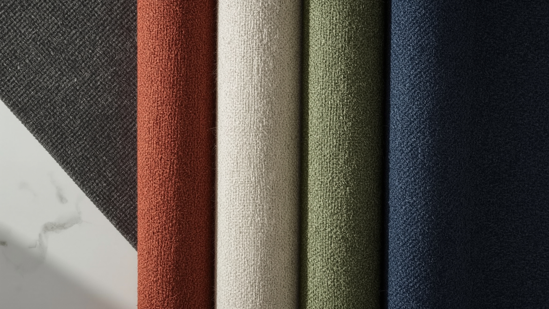 Five upholstery fabric swatches in macro detail showing microfiber polyester acrylic olefin linen and chenille textures